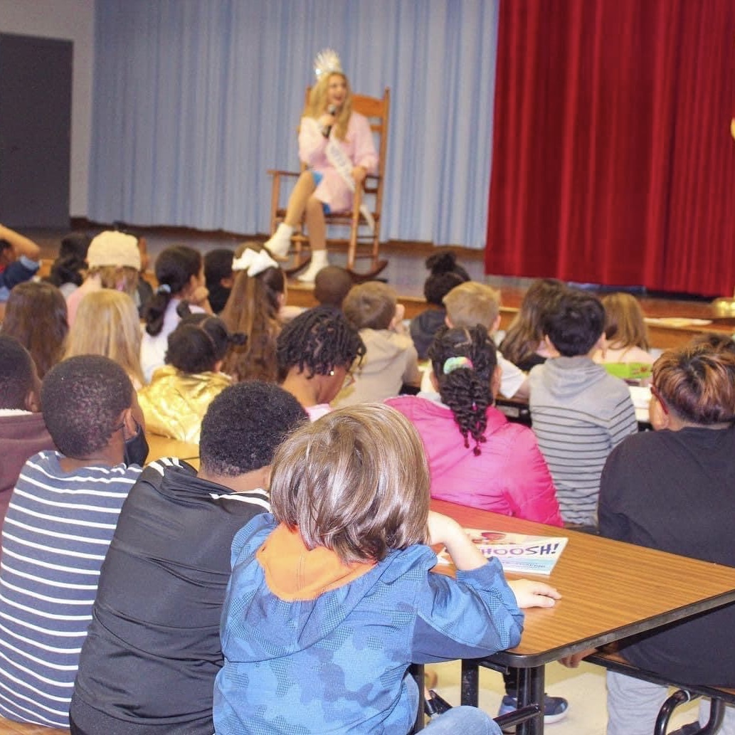 Lily speaks to children in a cafeteria